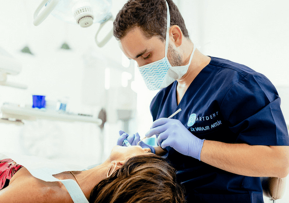 A budapesti fogászati rendelőben a szájsebész implantációs műtét előtt érzéstlenítőt ad a páciensnek.