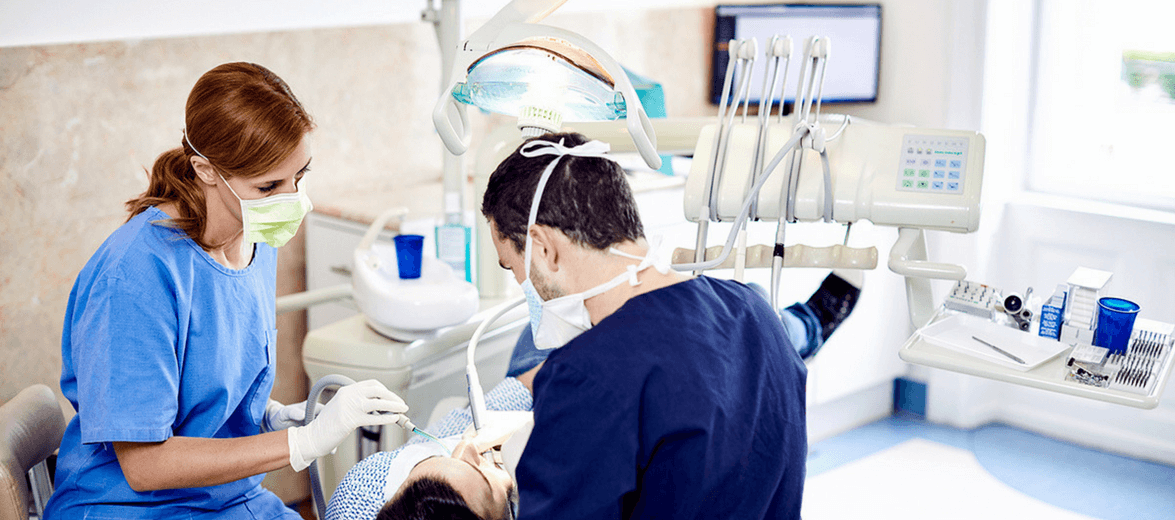 Budapesti fogászati rendelőben Dr. Varajti Artúr fogorvos, szájsebész fájdalommnetes, ultrahangos fogkőeltávolítást végez egy pácienssen.