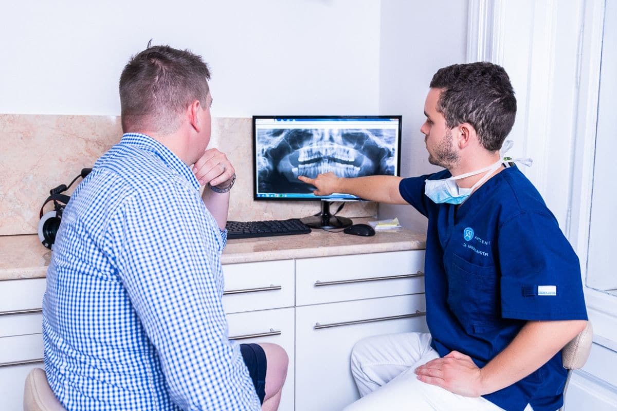 Dr. Varajti Artúr az ingyenes, ajándék szűrővizsgálaton mutatja a szájüregi röntgen eredményét az Artdent Fogászat páciensének