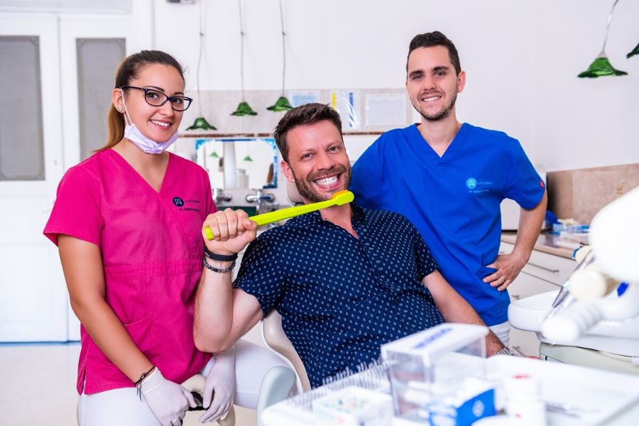 Ultrahangos fogkőeltávolítás után Dr. Varajti Artúr, Dr. Ökrös Petra, és páciensük mosolyognak.