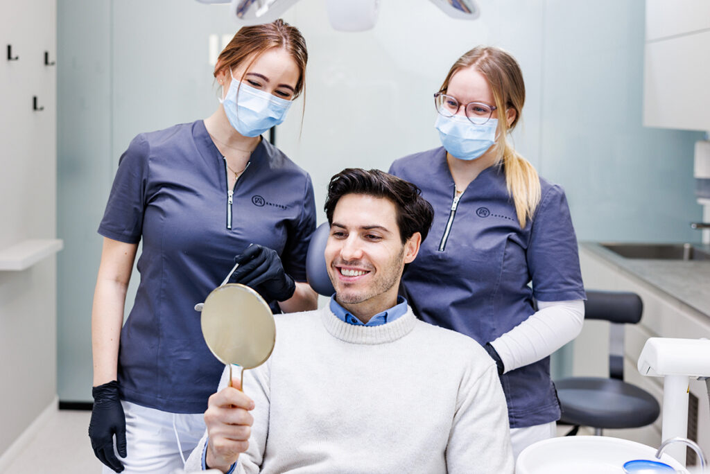 Az Artdent fogorvosai és elégedett páciensük ultrahangos fogkő-eltávolítás után | Artdent Fogászat és Szájsebészet, Budapest